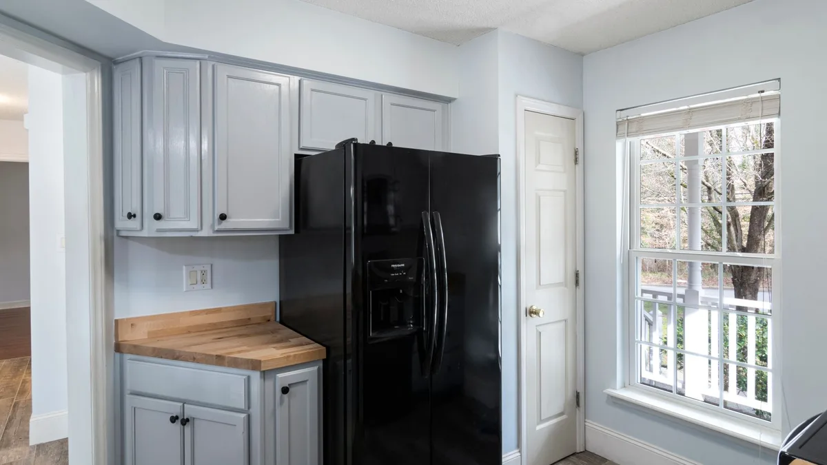 Frigorifico americano negro en una cocina con luz natural entrando por la ventana